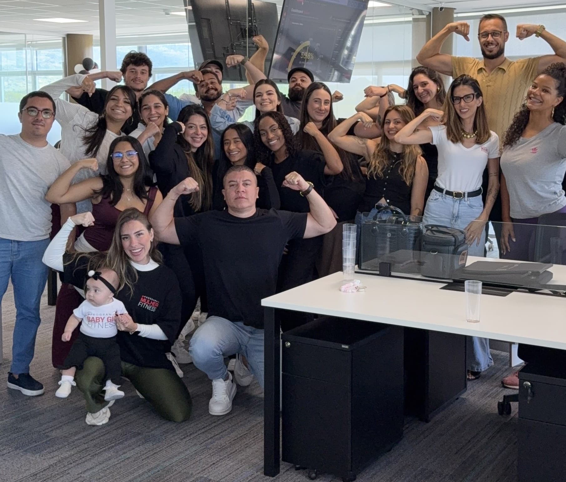Equipe da Amber reunida no escritório, várias pessoas com o braço flexionado.
